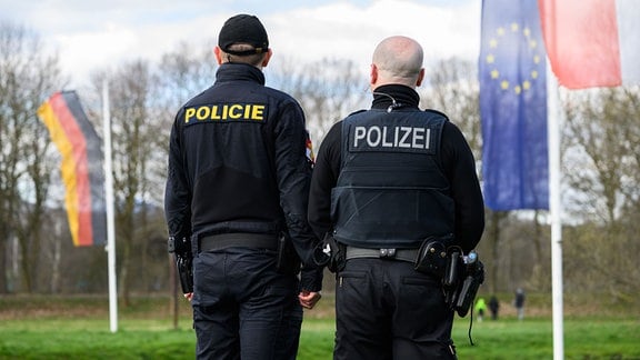 Ein Polizist aus Tschechien (l) und ein Bundespolizist stehen während eines Pressetermins am Dreiländereck von Deutschland, Polen und Tschechien