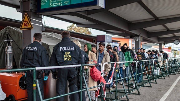 Flüchtlinge, von Polizisten bewacht, warten auf dem Bahnsteig, in einer Schlange auf einen Sonderzug, 2015