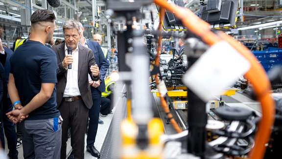 Robert Habeck (Bündnis 90/Die Grünen), Bundesminister für Wirtschaft und Klimaschutz, spricht bei einem Rundgang durch die Elektro-Montage des VW-Werkes Emden mit Mitarbeitenden.