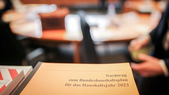 Ein Ordner liegt im Sitzungssaal mit der Bereinigungssitzung des Haushaltsausschuss des Bundestags.