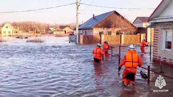 Überfluteter Ort mit Rettungskräften.