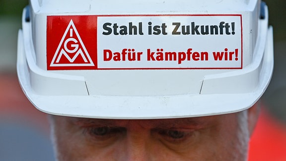 Ein Stahlarbeiter von ArcelorMittal Eisenhüttenstadt GmbH trägt 2022 einen Schutzhelm mit der Aufschrift "IGM Stahl ist Zukunft! Dafür kämpfen wir!"