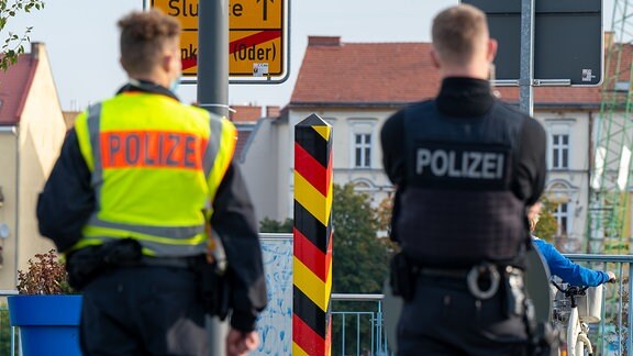 Zwei Polizisten kontrollieren den Verkehr auf der Grenzbrücke zwischen Deutschland und Polen.