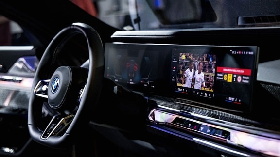 BMW i7 mit Videosystem in Fahrerkonsole und auf der Rückbank.