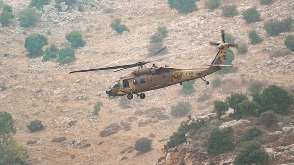 Ein israelischer Hubschrauber fliegt am Schauplatz eines Raketenangriffs aus dem Libanon in der drusischen Stadt Madschd al-Schams in den israelisch besetzten Golanhöhen zu sehen. 