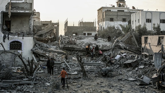 Palästinenser inspizieren nach einem israelischen Luftangriff ein zerstörtes Haus.