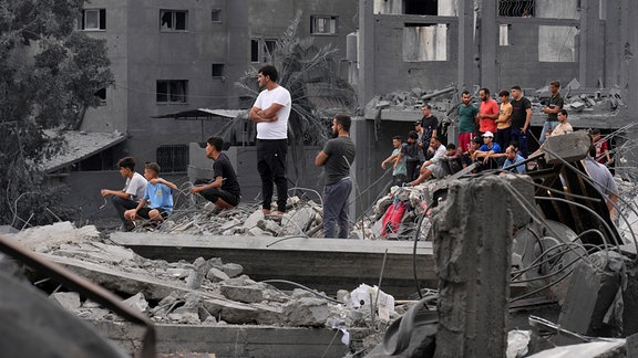 Palästinenser inspizieren die Trümmer eines Hauses, das von einem israelischen Luftangriff getroffen wurde.