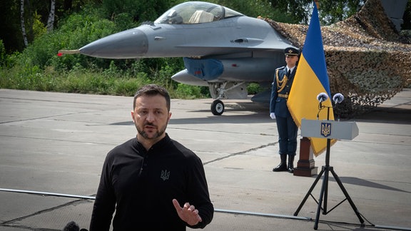 Wolodymyr Selenskyj, Präsident der Ukraine, beantwortet Fragen der Medien vor einem der F-16-Kampfjets der ukrainischen Luftwaffe. 