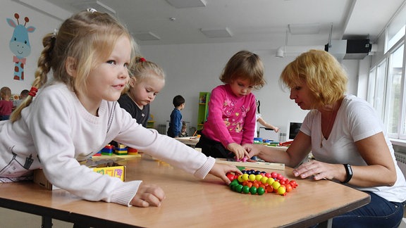 Eine Erzieherin spielt mit Kindern in russischem Kindergarten