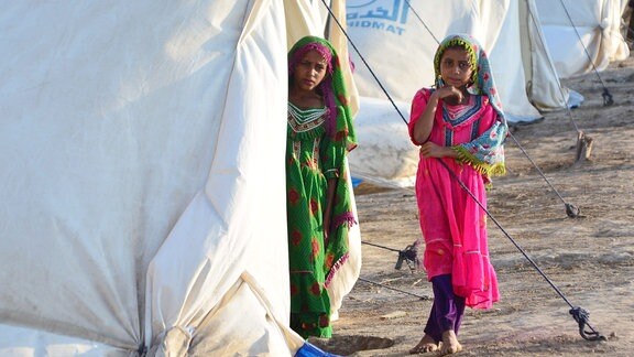 Von der Überschwemmung betroffene Kinder stehen am Eingang eines Zeltes der humanitären Hilfe am Stadtrand von Hyderabad.