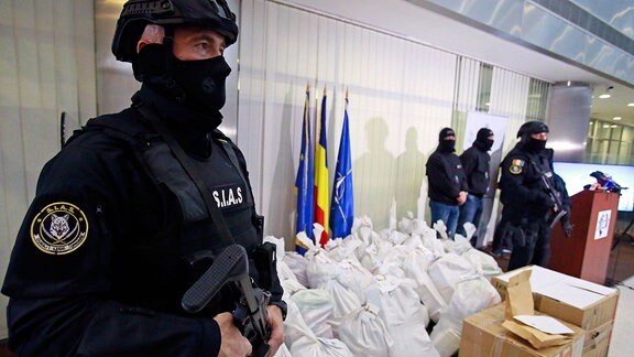 Rumänische Spezialpolizisten bewachen Säcke mit Kokain während einer Pressekonferenz.