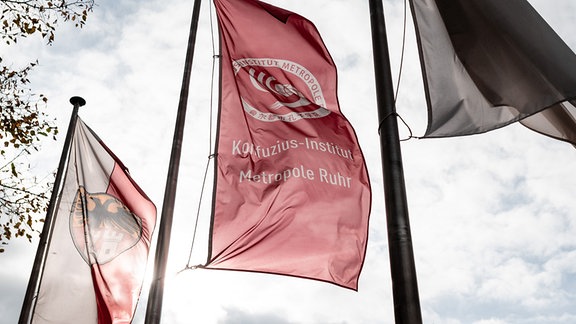 Auf eine Fahne vor dem Tectrum in Duisburg weht das Logo des Konfuzius-Instituts Metropole Ruhr.