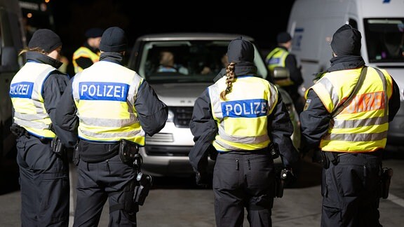 Polizisten stehen anlässlich von Grenzkontrollen auf dem Rastplatz "Am Heideholz" an der Autobahn 17 nahe der deutsch-tschechischen Grenze. 