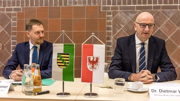 Michael Kretschmer (CDU, l) Ministerpräsident des Freistaates Sachsen und Dietmar Woidke (SPD), Ministerpräsident des Landes Brandenburg, sitzen bei einem Pressegespräch vor dem länderübergreifenden Netzwerktreffen der Modellregion Gesundheit Lausitz