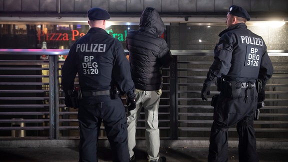 Ein Bundespolizist kontrolliert im Bahnhof Gesundbrunnen einen Mann. 