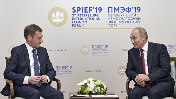 Ministerpräsident Michael Kretschmer und Russlands Präsident Wladimir Putin sprechen während eines Treffens auf dem 23. Internationalen Wirtschaftsforum in St. Petersburg, 2019
