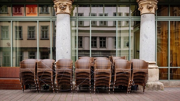 Gestapelte Stühle vor geschlossenem Restaurant