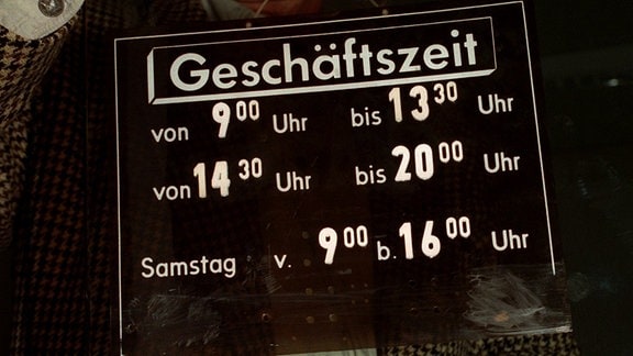 Schild mit Öffnungszeiten wird 1995 an eine Tür gehalten