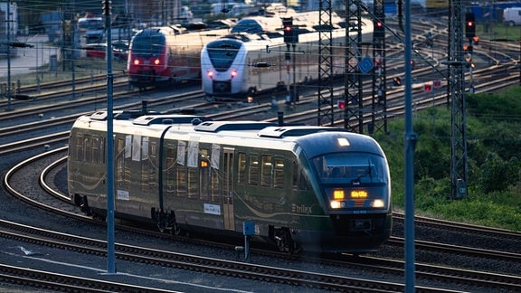 Ein Trilex Zug der Länderbahn fährt am Morgen auf einem Gleis entlang.