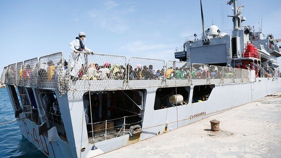 Migranten sitzen an Bord der «Cassiopea» eines der Patrouillenschiffe der italienischen Marine. 