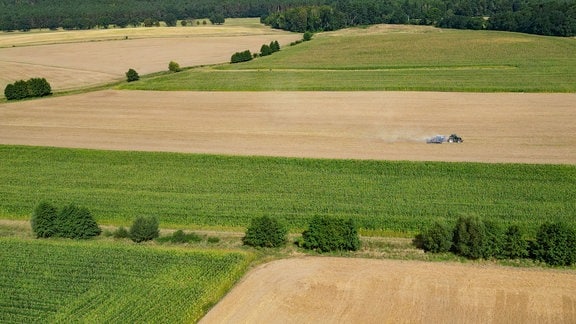 Ein Landwirt drillt Saatgut in den trockenen Ackerboden auf einem Feld im Landkreis Oder-Spree in Ostbrandenburg.