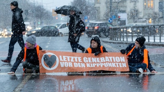 Aktivisten der „Letzten Generation“ kleben sich auf der Dresdner Bergstraße fest und wollen damit auf die Einhaltung der Klimaziele aufmerksam machen. 
