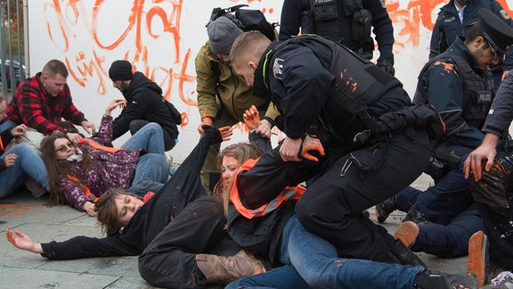 Aktivisten der Gruppe Letzte Generation werden vor dem Kanzleramt von Polizeibeamten zu Boden gebracht.