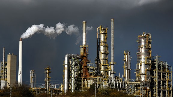 Die Anlagen der TotalEnergies Raffinerie Mitteldeutschland GmbH in Leuna, über der schwarze Wolken ziehen.