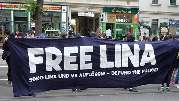 Teilnehmer einer linken Demonstration versammeln sich im Stadtteil Connewitz und tragen ein Transparent mit der Aufschrift „Free Lina“.