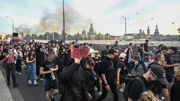 Demonstranten aus dem linken Spektrum demonstrieren gegen das Urteil im Prozess um Lina E. und drei Männer und laufen dabei über die Carolabrücke, einer hält ein Schild mit der Aufschrift "Nazis ermorden"