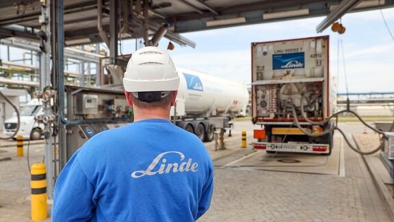 Ein Mitarbeiter überwacht das Befüllen von Lkw mit flüssigem Wasserstoff bei der Linde AG im Chemiepark Leuna.
