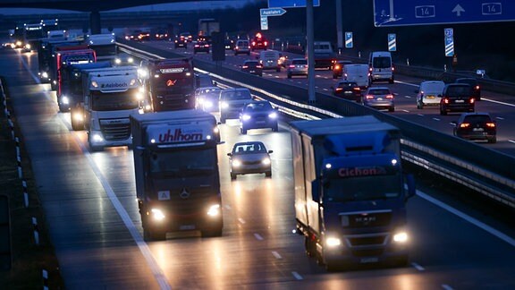 Autos und Lastkraftwagen fahren am frühen Morgen über die A14 bei Radefeld.