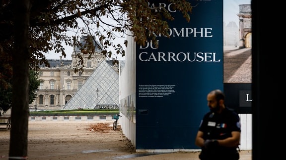 Ein Polizist steht vor dem Louvre Wache, der wegen einer Bombendrohung geräumt worden