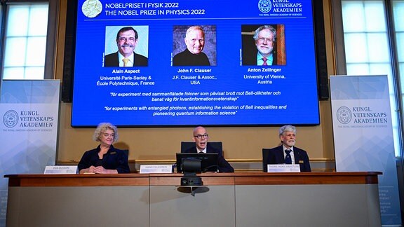 Hans Ellegren, Eva Olsson und Thors Hans Hansson geben die Gewinner des Nobelpreises für Physik 2022 bekannt: Alain Aspect, John F. Clauser and Anton Zeilinger