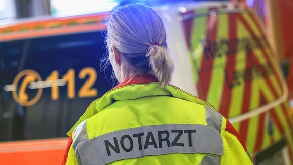 Eine Notärztin steht bei einer Schockraumübung der Feuerwehr Leverkusen an einem Rettungswagen.