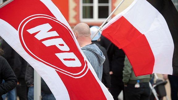 Mit wehenden Fahnen ziehen Anhänger der rechtsextremen NPD durch die Innenstadt von Greifswald. 