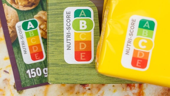 Mehrere Verpackungen von Lebensmitteln mit Nutri-Score-Symbol nebeneinander.