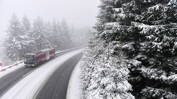 Ein Bus fährt 2017 durch den winterlichen Thüringer Wald in Oberhof.