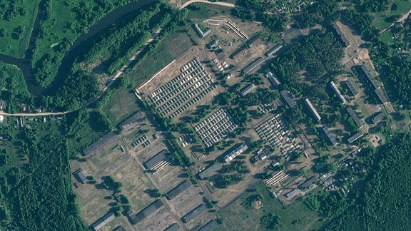 Dieses von Planet Labs PBC zur Verfügung gestellte Satellitenbild zeigt kürzlich errichtet Zelte auf einem ehemaligen Militärstützpunkt außerhalb der belarussischen Stadt Osipowitschi. 