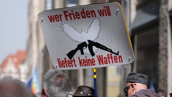 Ein Schild mit dem Schriftzug „Wer Frieden will, liefert keine Waffen“ wird auf einer Kundgebung gehalten. 