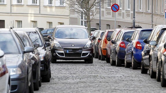 Beiderseitig parkenden Autos in einer Straße.