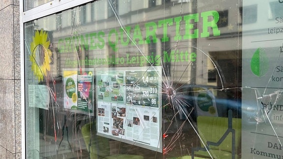 Graffitti und eine zerbrochene Fensterscheibe am Parteibüro der Grünen in Leipzig.