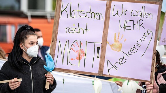 Eine Frau hält bei der Aktion «Der Pflege geht die Luft aus» der Bundespflegekammer und des Berliner Walk of Care ein Plakat mit der Aufschrift "Klatschen reicht nicht. Wir wollen Anerkennung". 