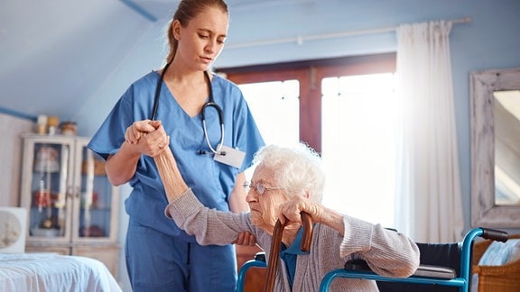 Illustration Pflege - Pflegerin hilft älterer Dame im Rollstuhl