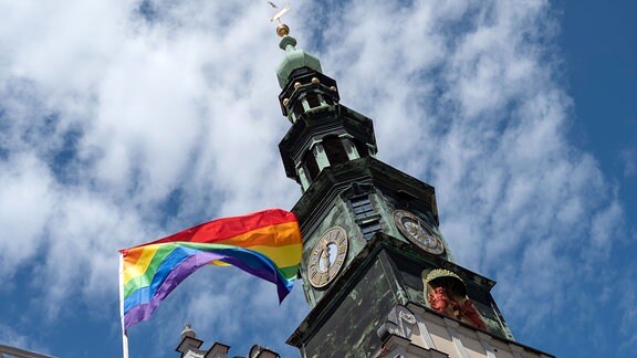 Eine Regenbogenfahne weht über einer Bühne in Nähe des Rathauses beim Christopher Street Day in Pirna.