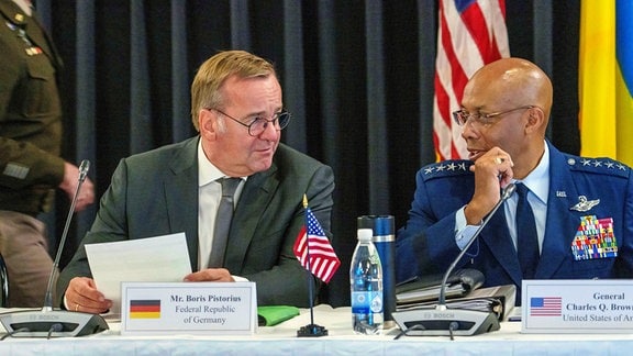 Boris Pistorius (SPD, l), Bundesverteidigungsminister, und Charles Q. Brown Jr., Generalstabschef der Streitkräfte der USA, unterhalten sich beim Treffen der Ukraine-Kontaktgruppe auf der US Air Base Ramstein