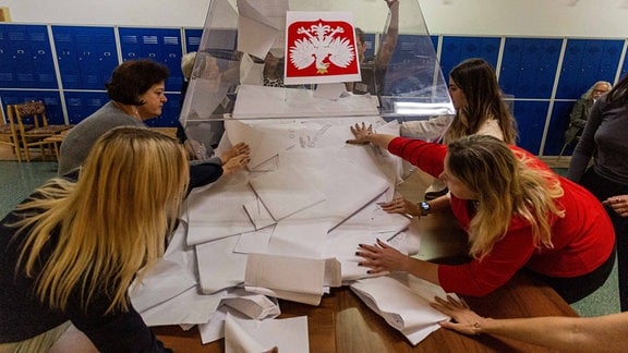 Wahlhelfer entleeren eine Wahlurne.