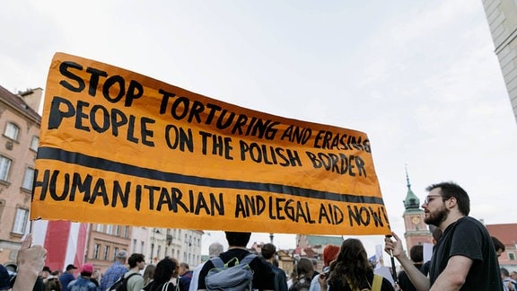 Demonstranten halten während der Demonstration ein Banner mit der Aufschrift „Hört auf, Menschen an der polnischen Grenze zu foltern und auszulöschen. 