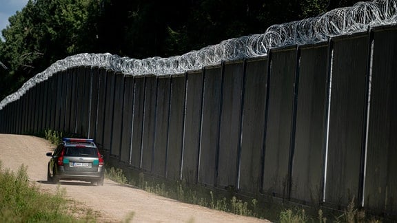 Ein Fahrzeug der polnische Grenzschützer fährt am Grenzzaun auf der polnischen Seite zu Belarus entlang.