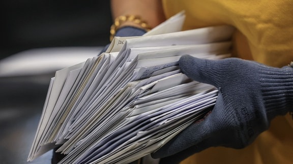 Eine Mitarbeiterin der Deutschen Post DHL sortiert Briefe im Briefverteilzentrum.  